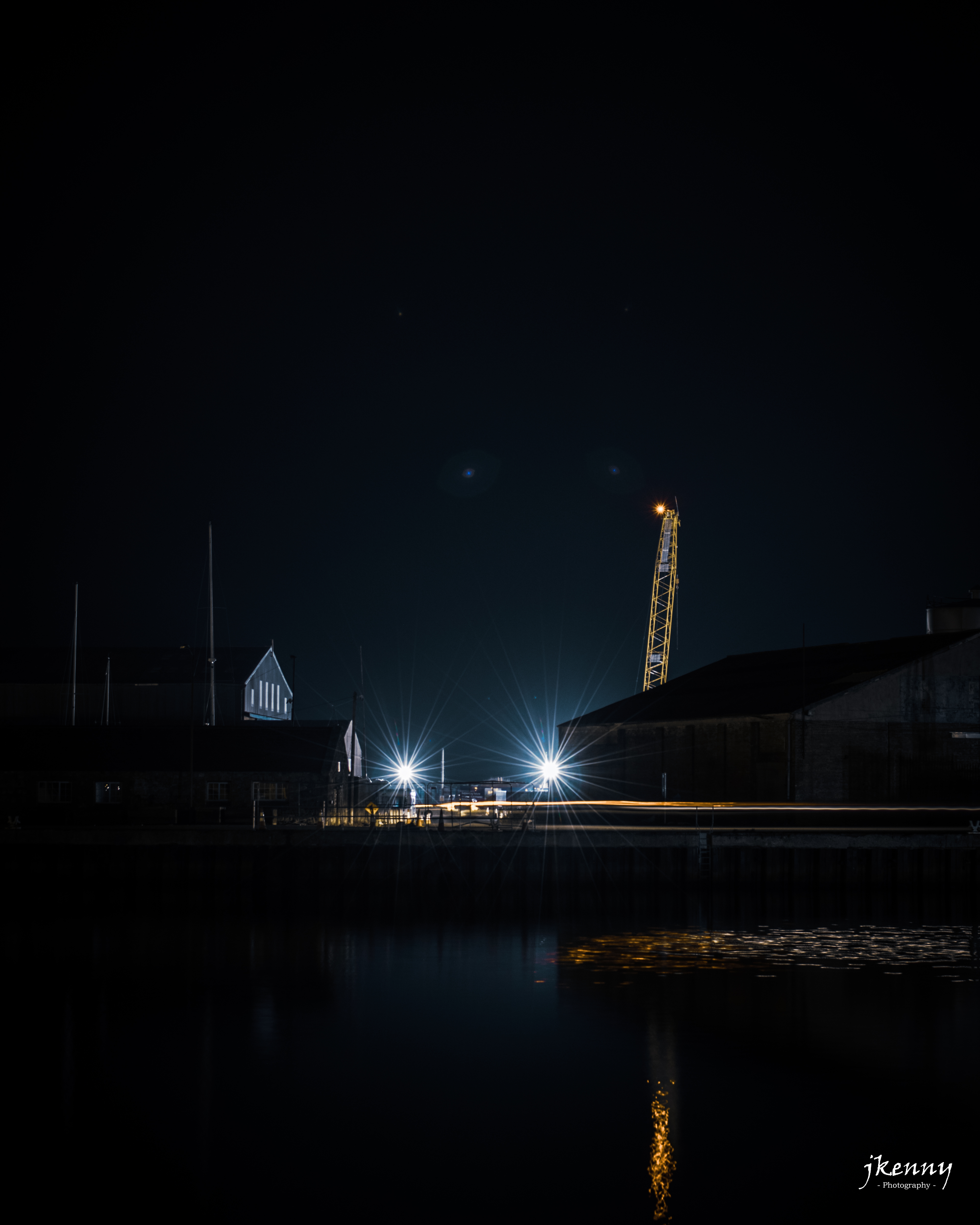 Night photo, traffic driving between two buildings.