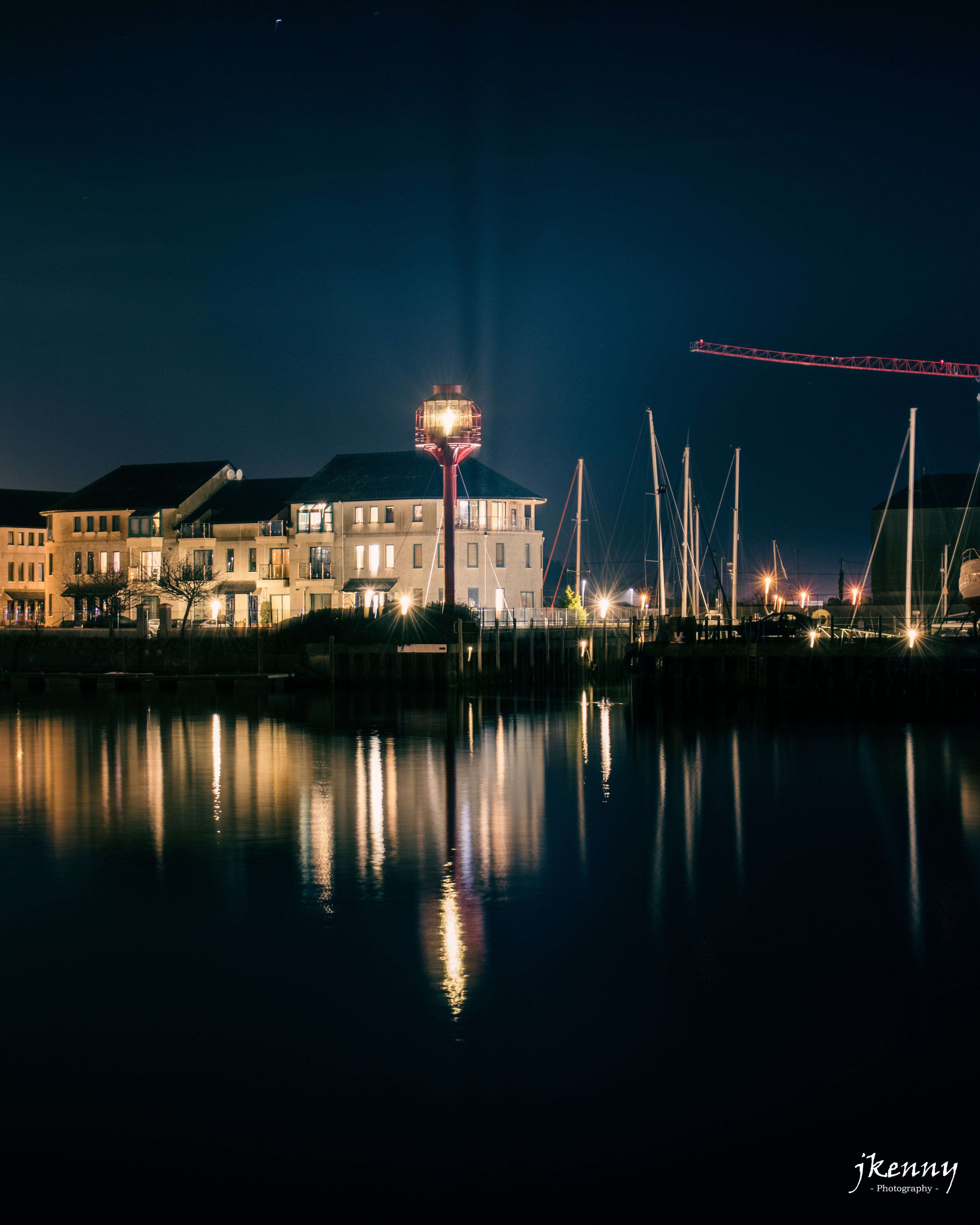 Night photo of the light house on the river.