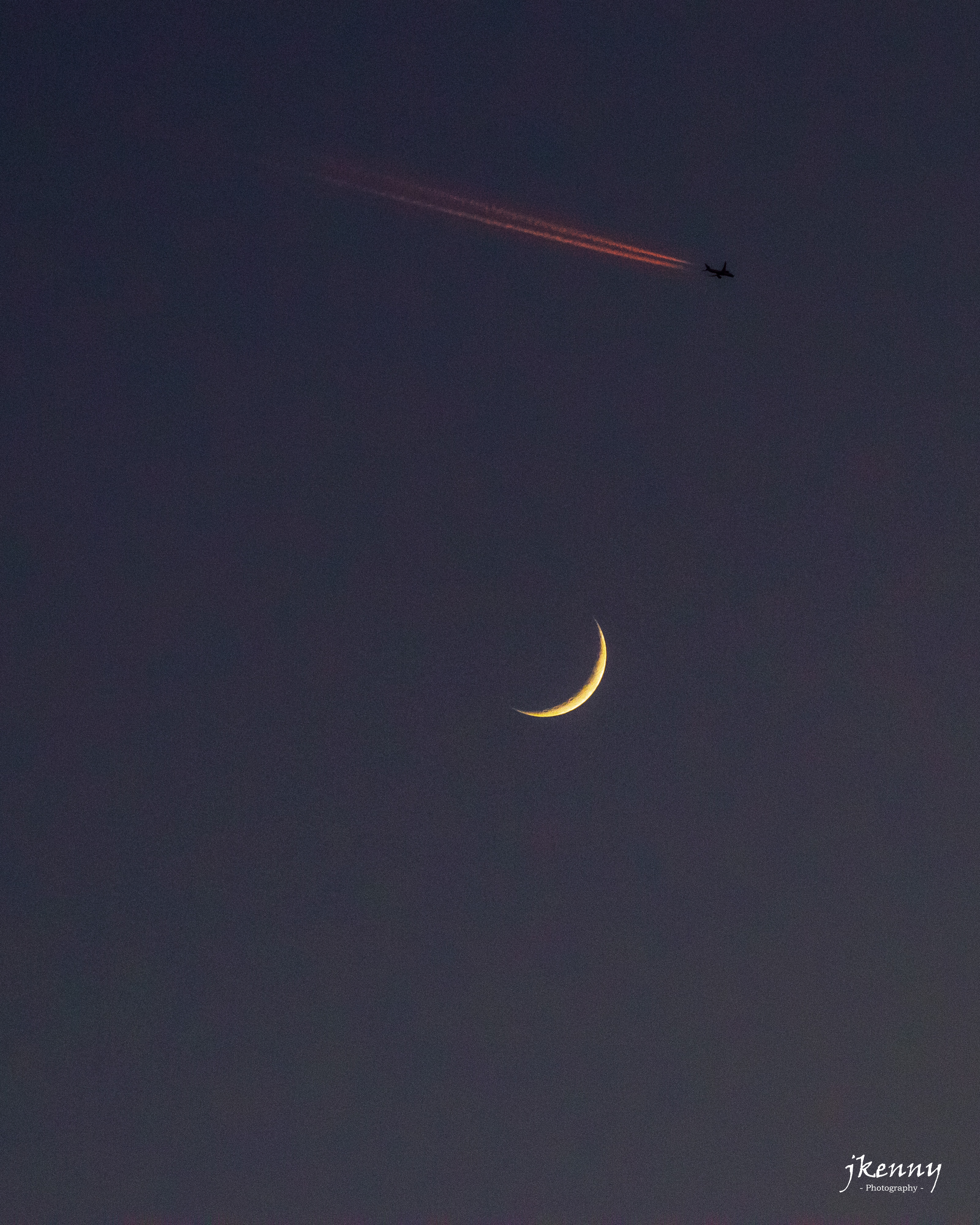 A plane flying past the moon.
