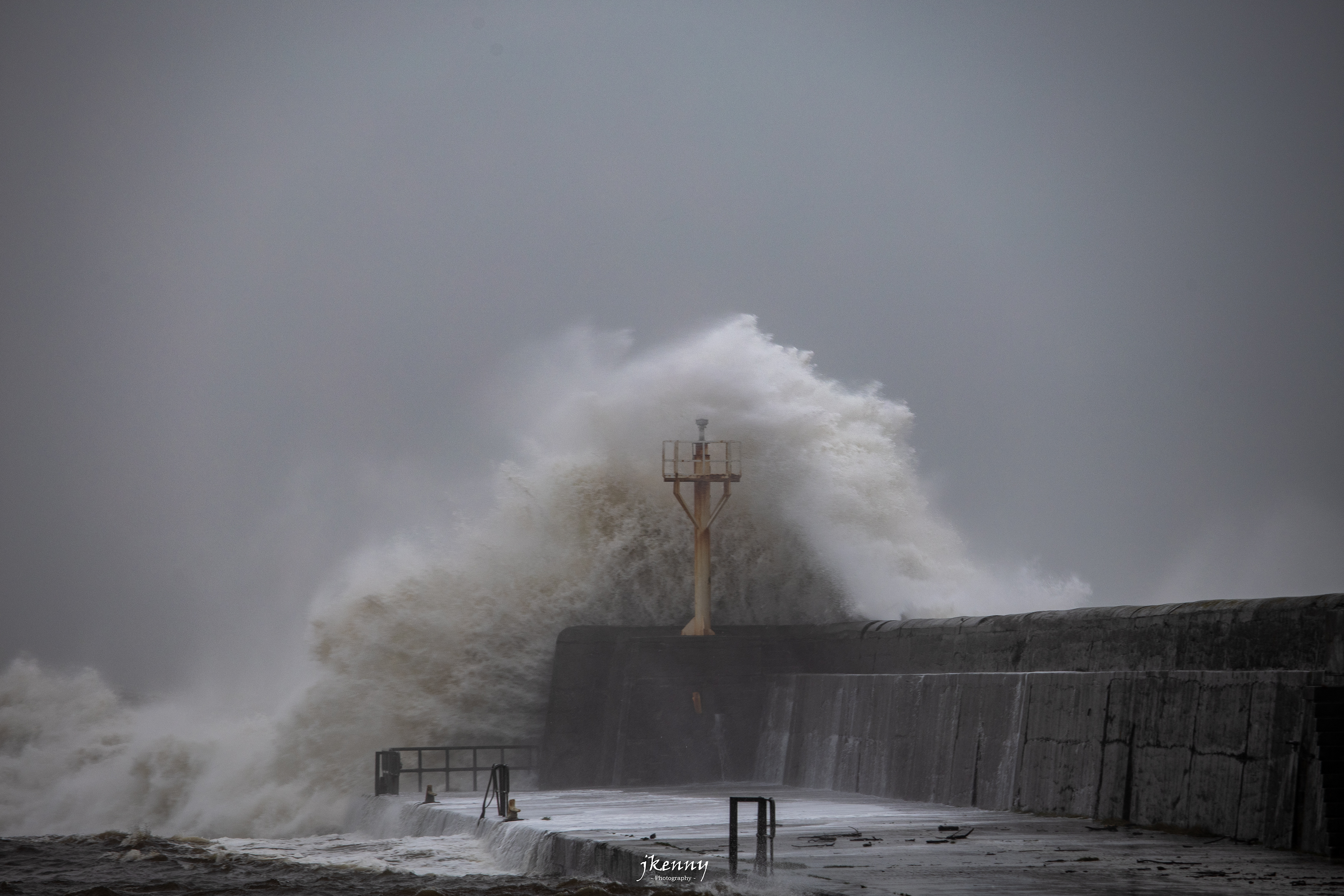 Waves crashing over the harbour.